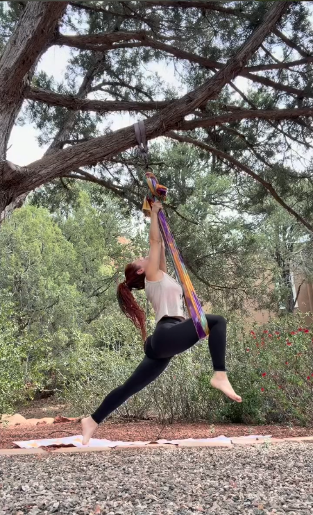 Spinning on a rainbow aerial silk under the pines
