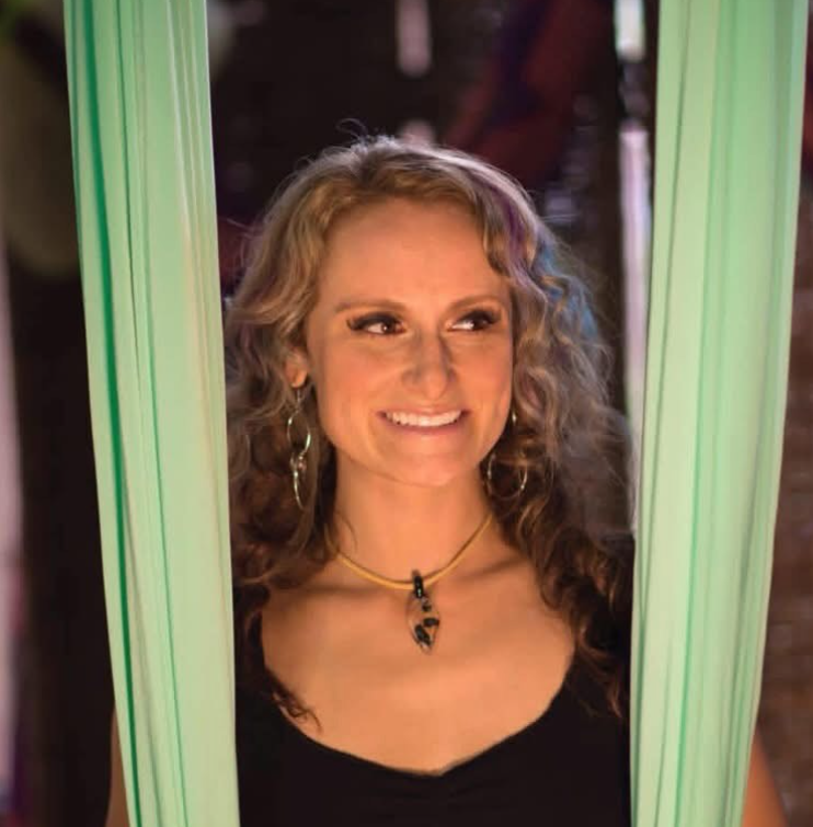Christina smiling between mint-green aerial silks