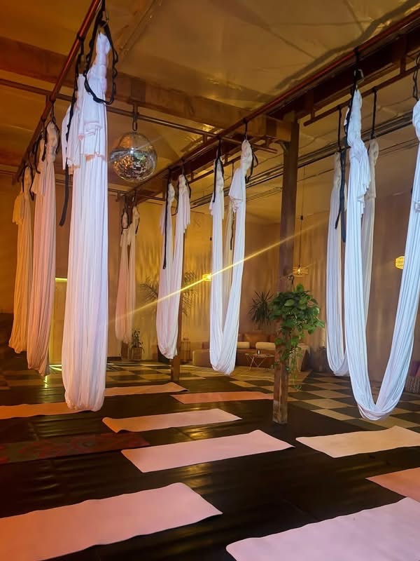 The studio set up for a private aerial party, hammocks hanging over rows of mats